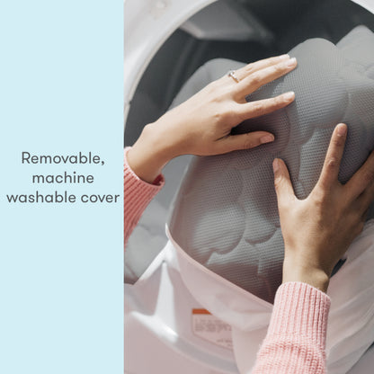 hands placing wateproof mattress cover in washing machine with text, "removable, machine washable cover"