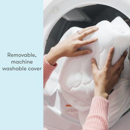 hands placing wateproof mattress cover in washing machine with text, "removable, machine washable cover"