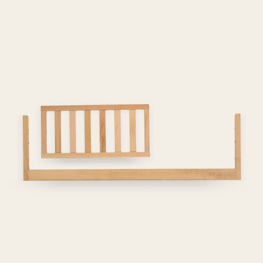 Light wooden baby crib side rail on a white background.