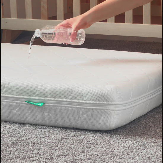 Vide of water being poured on newton waterproof mattress and not seeping through to core because of waterproof lining. 999-1000-WHT-ST