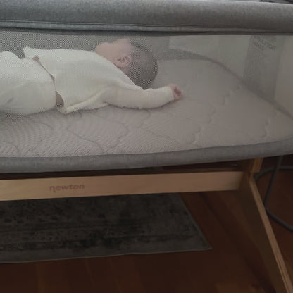 panning camera shot of a baby lying asleep in the newton bassinet & bedside sleeper 
