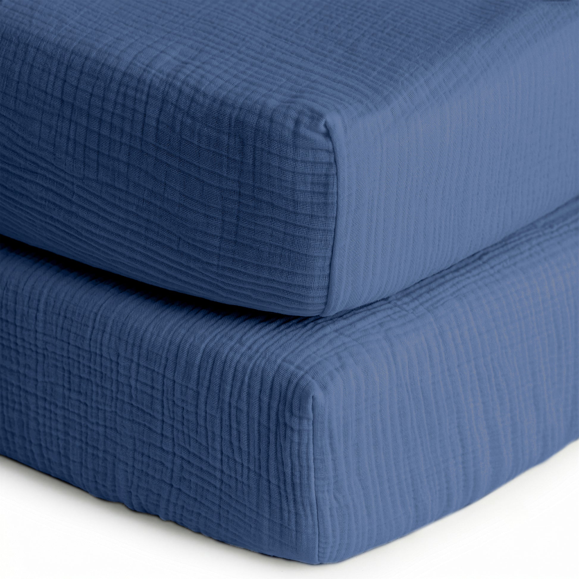 Two breathable, organic cotton sheets (2-pack) from Newton Baby—ideal for crib mattresses—with a soft, quilted texture, shown in blue up close against a white background.