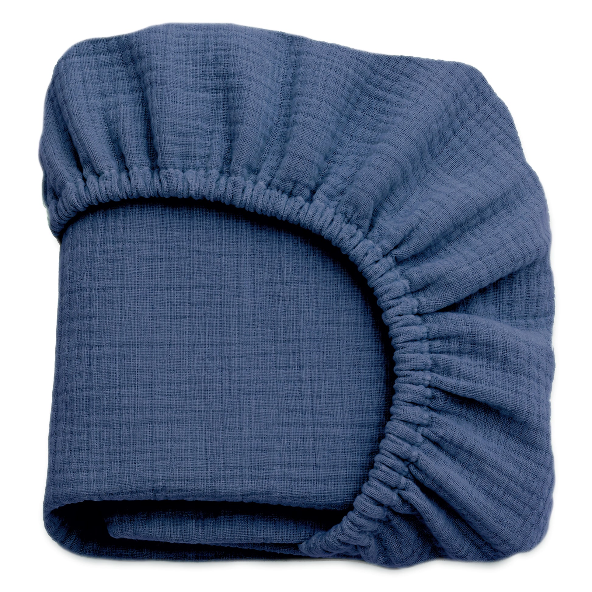 A neatly folded dark blue Newton Baby Breathable, Organic Cotton Sheet from a 2-pack set, featuring elastic edges and textured organic cotton, is displayed against a white background. 999-3020-EVB