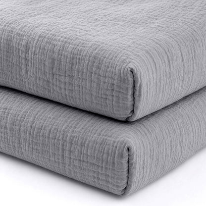 Two neatly folded, textured gray Newton Baby Breathable, Organic Cotton Sheets (2-pack) stacked together against a white background, highlighting their soft, cozy quality for your crib.