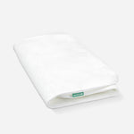 White Newton baby mattress with a breathable, quilted pattern design and a visible brand tag.