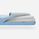 Stacked layers of a breathable Newton baby mattress with a removable washable cover. skip