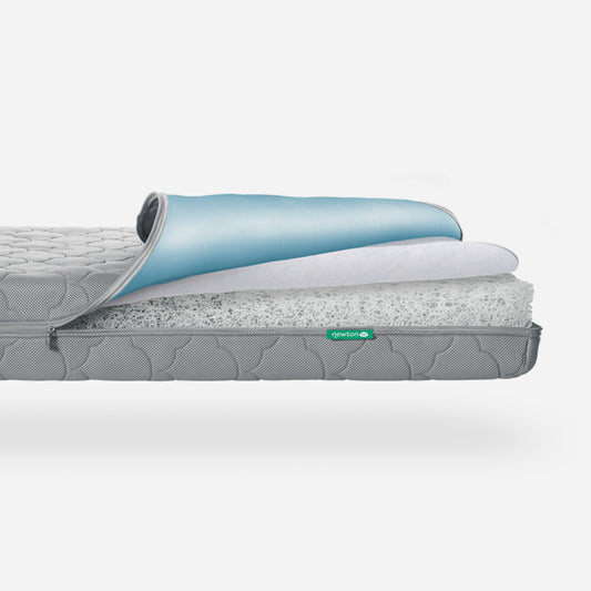 Cross-section of a Newton Baby crib mattress showing its internal structure and layers, with the Newton logo visible. skip