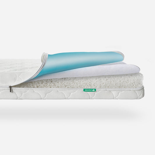 Newton Crib Mattress shown partially disassembled with layers exposed, highlighting breathable and waterproof materials and the green Newton logo. skip