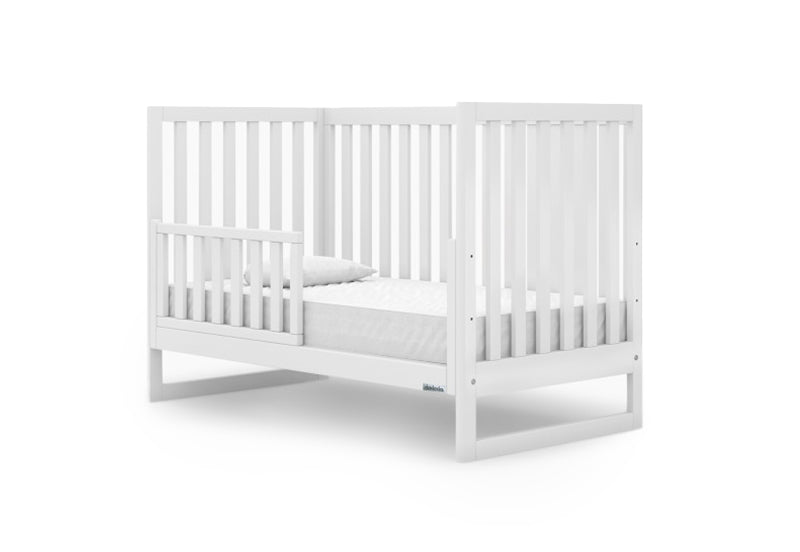 White wooden baby crib with a mattress, isolated on a white background.