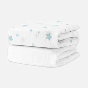 A stack of two bvaby crib sheets featuring a top sheet with a light blue star pattern on a white background, set against a plain white background. skip