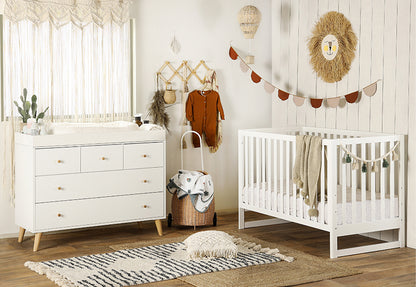 A cozy and stylish nursery room featuring a white crib and dresser, decorated with warm, earthy tones, and playful safari accents. 500-8200-WHT