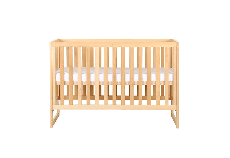 Wooden baby crib with mattress on a white background.