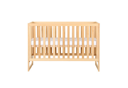 Wooden baby crib with mattress on a white background.